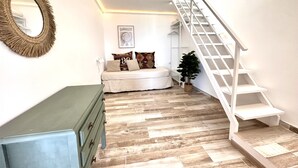 A bedroom with a bed, a dresser, a mirror, a staircase, and a potted plant. - Eden Gomera Suites - Rooftop terrace 2Br apartment with gorgeous oceanviews (Lepe)
