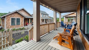 A covered deck with wooden furniture and a view of neighboring houses. - *New* Beach Hair Don't Care, hot tub, close to pool (Pacific Beach)