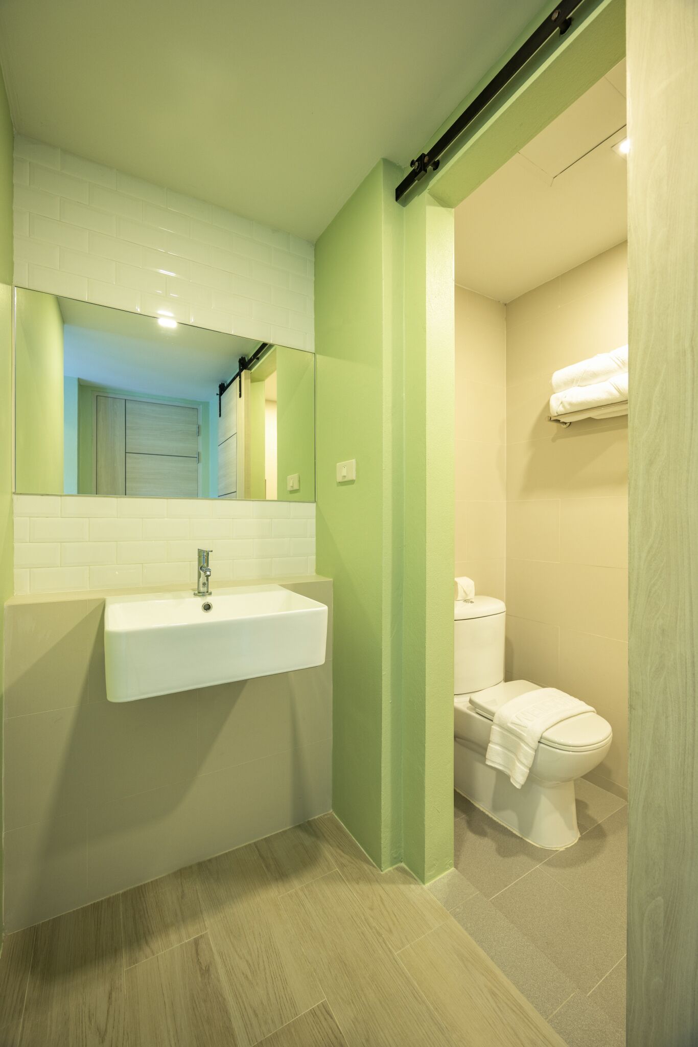 A bathroom with a white sink, a mirror, and a toilet.