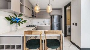 A modern kitchen with a central island, stainless steel appliances, and pendant lighting.