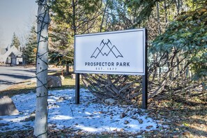 A sign for Prospector Park with a mountain logo, established in 1977, surrounded by trees and snow. - Quiet End, Ground Floor, Ski Bus | Sleeps 4 | Moose Mgt 805 (Park City)