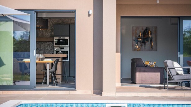A modern outdoor living area with a pool, a dining space with a table and chairs, and a seating area with a sofa and cushions. - Awesome home in Svetvincenat (Svetvincenat)