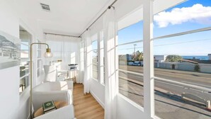 A bright room with large windows, a white sofa, a small table, and a lamp. - Casa Aurelia by Oraklus (Malibu)