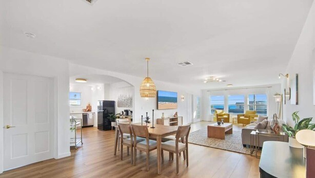 A spacious living area with a wooden dining table, comfortable seating, and a view of the outdoors. - Casa Aurelia by Oraklus (Malibu)