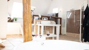 Une salle de bain moderne équipée d’une baignoire, d’une douche et d’un espace coiffeuse.