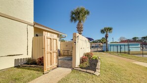 A residential property with a gated entrance, a patio area, and a pool in the background.
