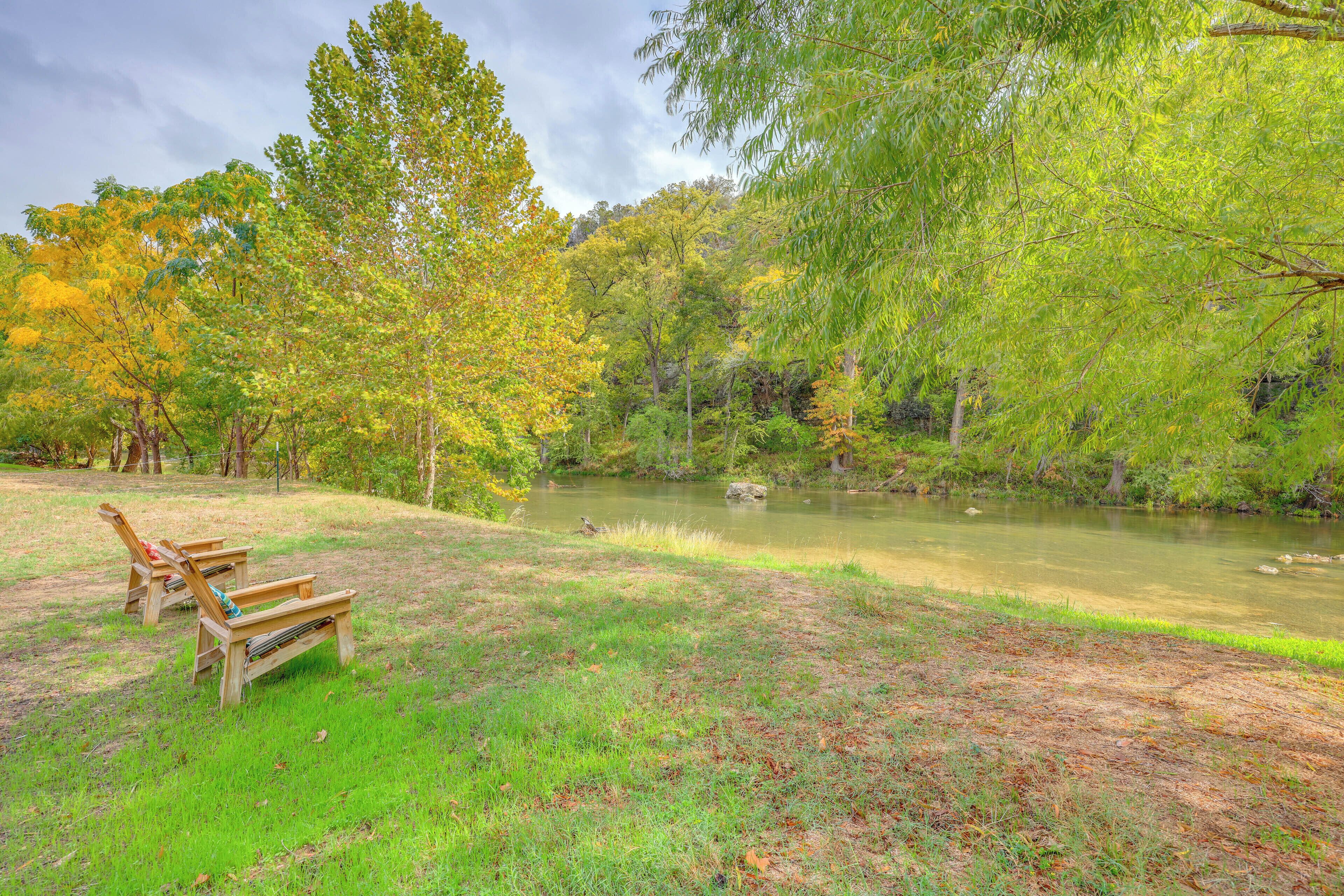 A serene park with a pond, benches, and lush trees.