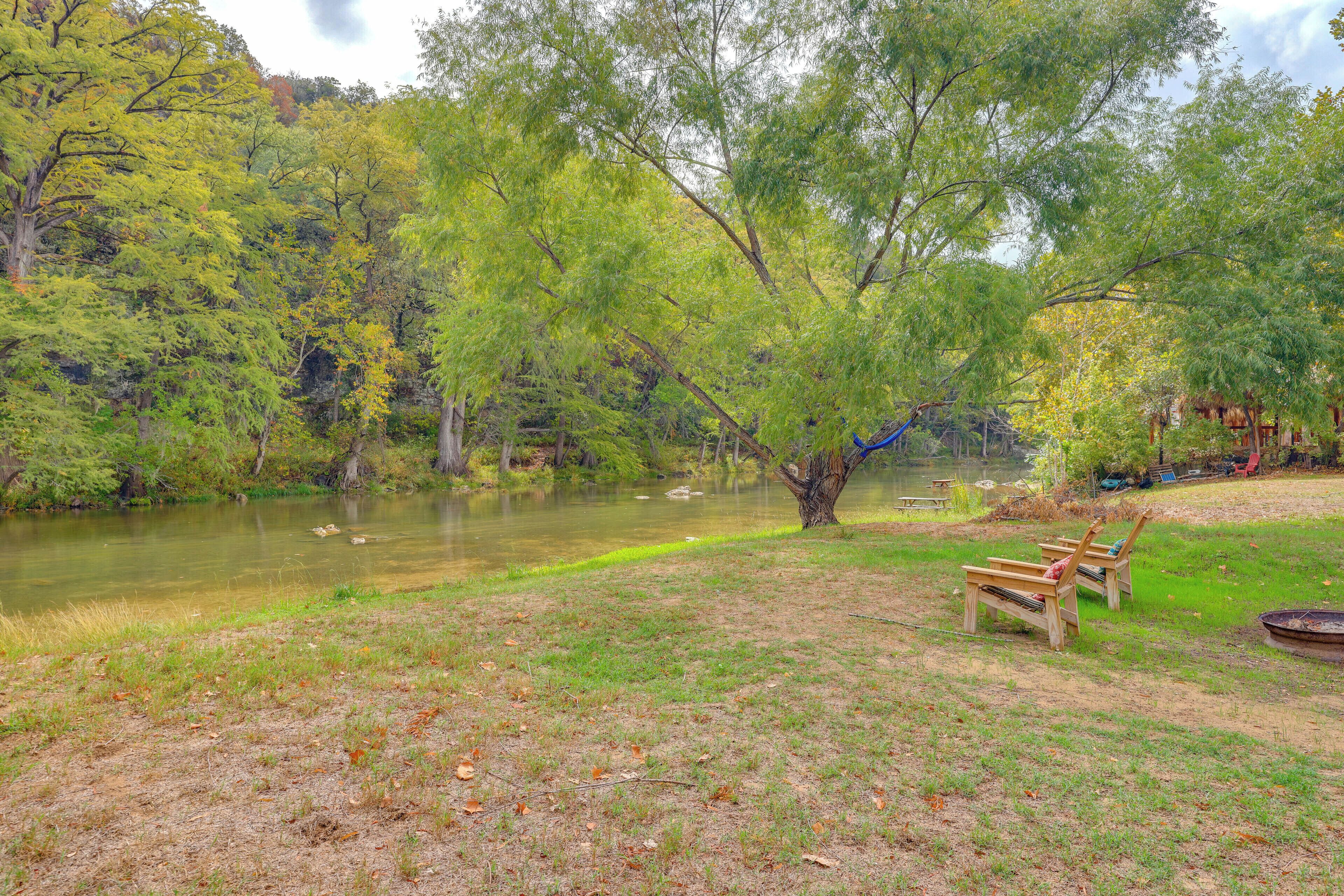 Un parque junto al río con un banco y una mesa para picnic.