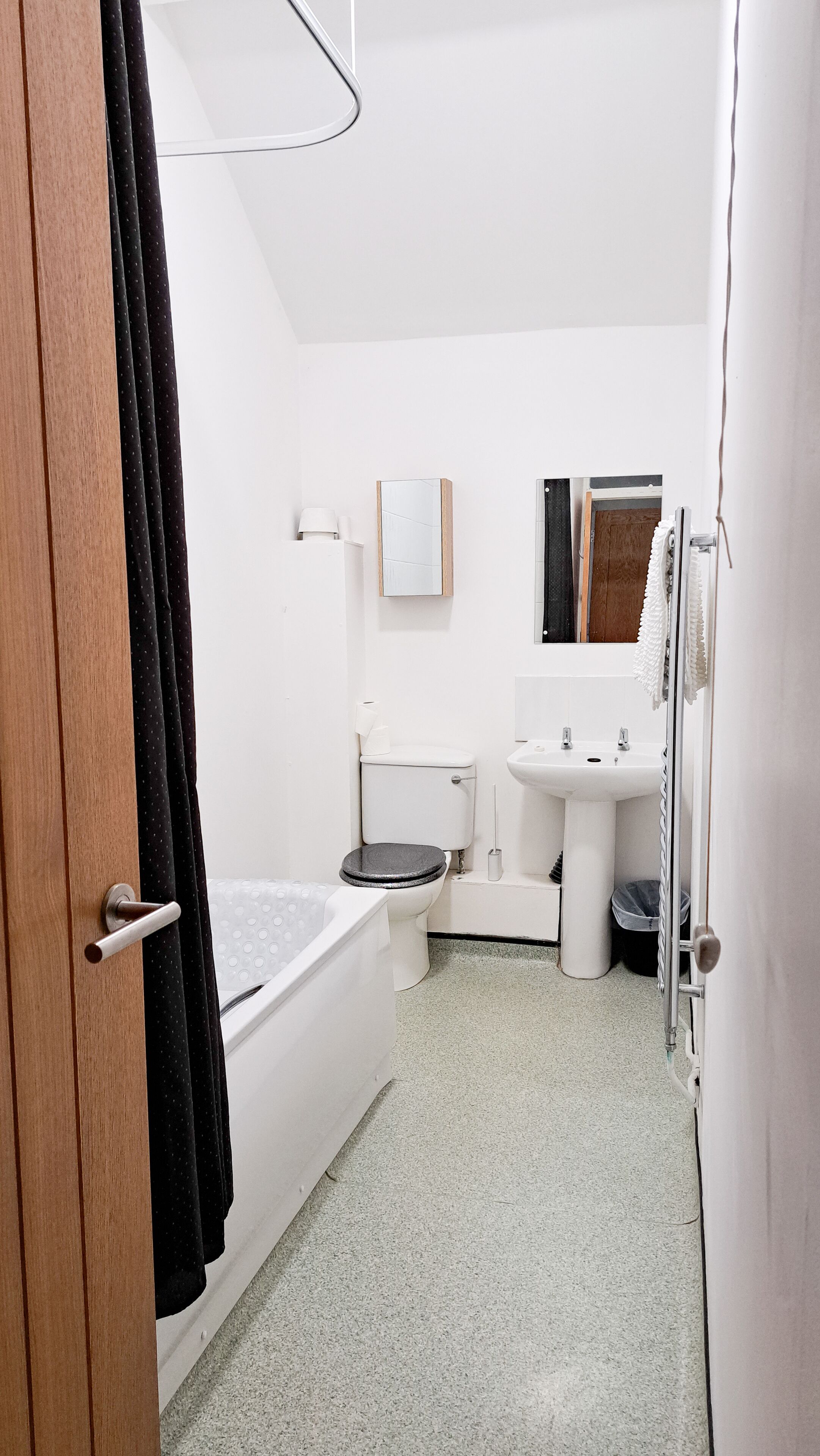 A small, compact bathroom with a toilet, sink, and bathtub.