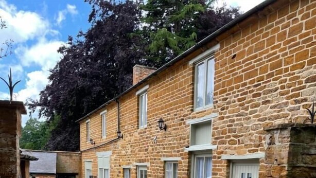A courtyard with stone buildings, a cobblestone path, and a gate. - The Old Vicarage (Northampton)