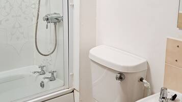 A bathroom with a shower, toilet, and sink.