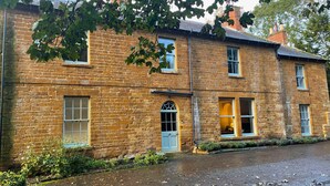 A two-story brick building with multiple windows, a door, and a small porch area. - The Old Vicarage (Northampton)