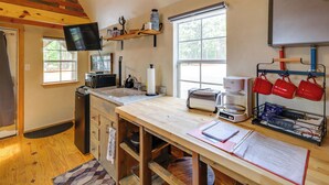 A kitchen with a wooden countertop, a coffee maker, a toaster, and a flat-screen TV mounted on the wall. - Cozy Higden Studio: Close to Greers Ferry Lake! (Higden)