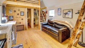 A cozy room with a bunk bed, a leather couch, a ladder, and a wooden ceiling. - Cozy Higden Studio: Close to Greers Ferry Lake! (Higden)