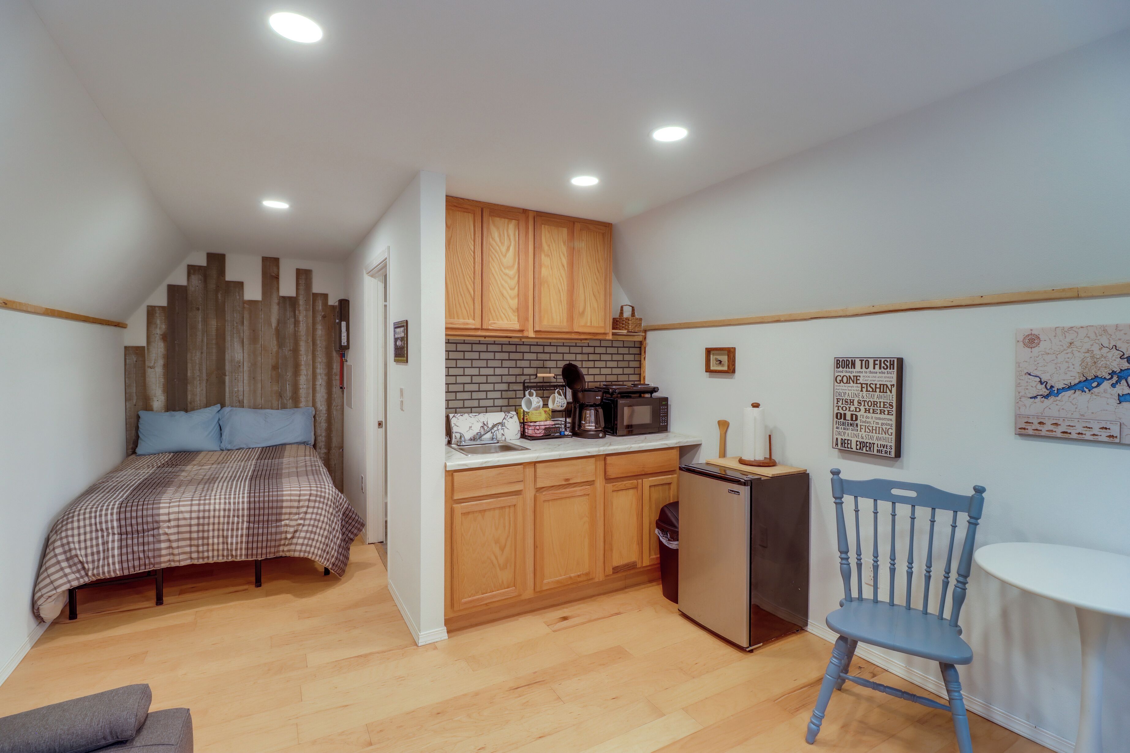 A compact room with a bed, kitchenette, and a small dining area.