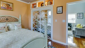 A bedroom with a bed, a wardrobe, and a door leading to another room. - Inviting Quincy Cottage: Walk to Historic Downtown (Quincy)