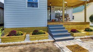 A house with a porch, wooden steps, and raised flower beds. - Inviting Quincy Cottage: Walk to Historic Downtown (Quincy)