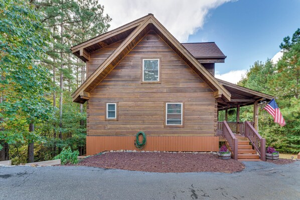 A wooden cabin with a porch, a small window, and a wreath on the front.