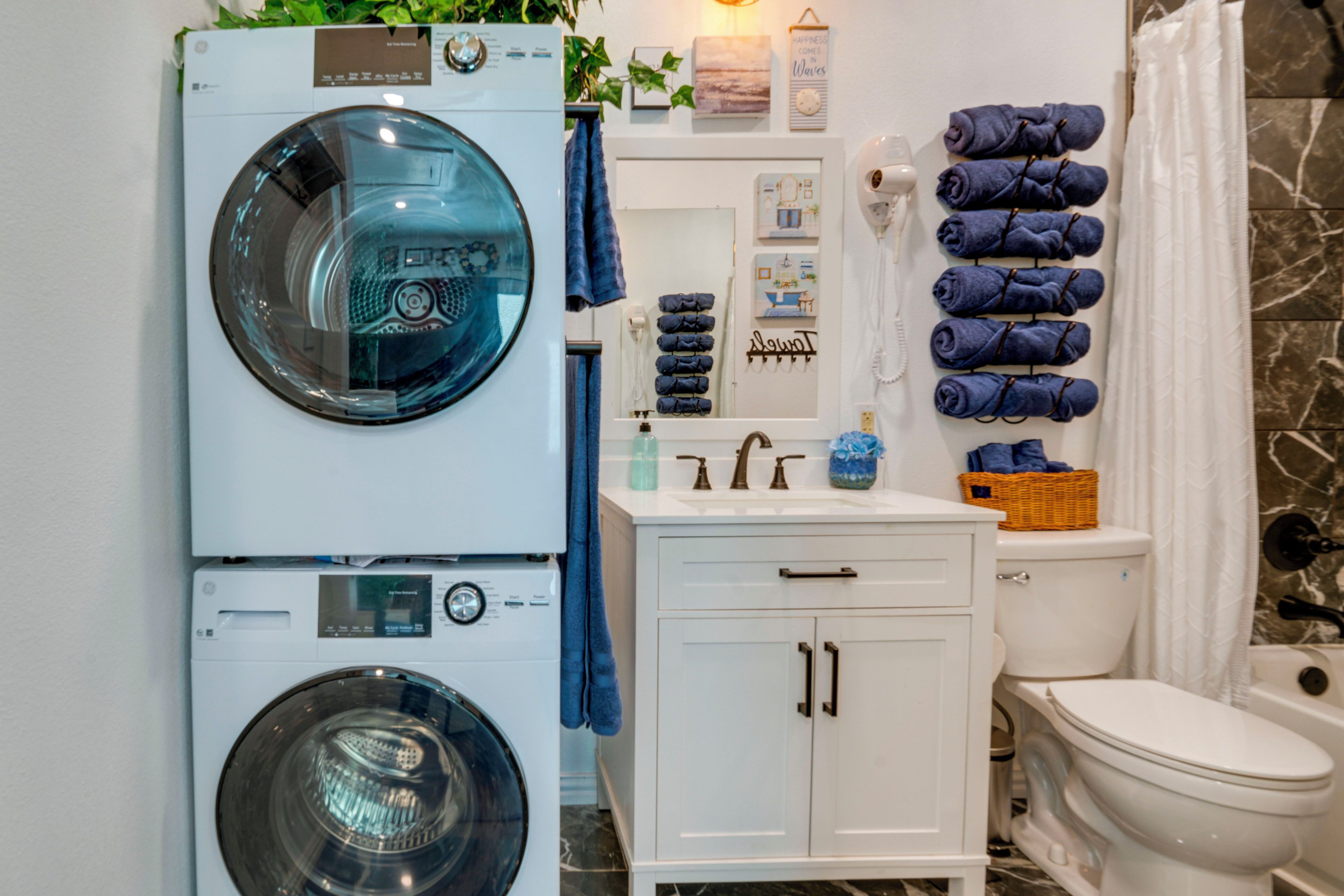 A compact bathroom with a washing machine, a sink, and a toilet.