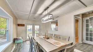 A dining area with a long table, chairs, and a hanging light fixture. - Dry Ridge Rental Home w/ Hot Tub & Game Room! (Crittenden)
