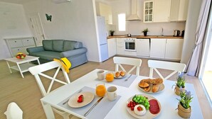 A modern apartment with a dining area, kitchenette, and a living room. - Ferienwohnung Ocean Sounds A in Gran Tarajal, Innenstadt, Meerblick, Terrasse (Gran Tarajal)