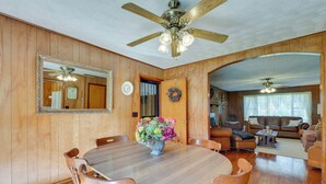 A dining area with a wooden table and chairs, a vase of flowers, and a ceiling fan. - Haysi Nature Getaway w/ Fire Pit & On-site Creek! (Haysi)