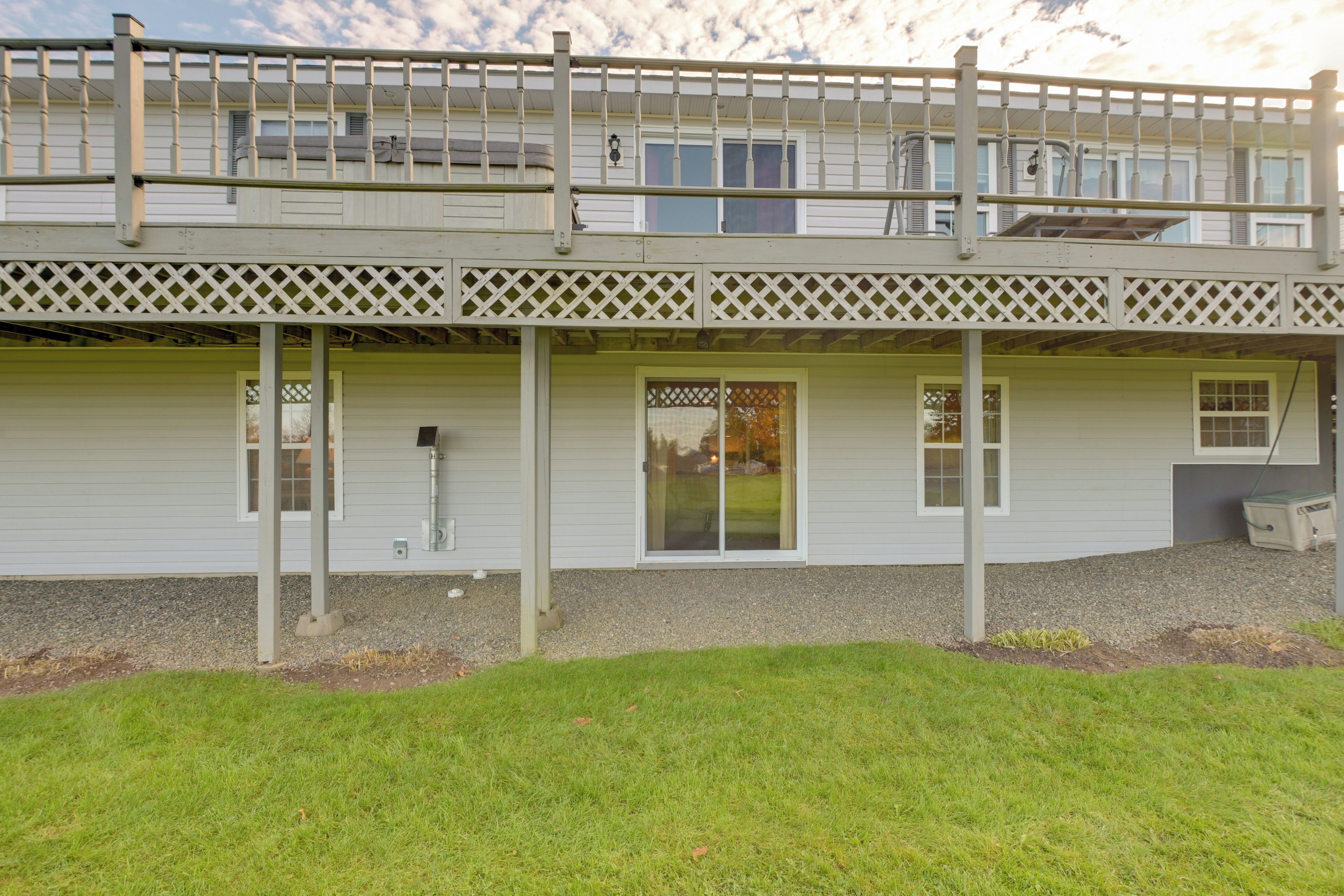 A two-story house with a covered porch, a garage, and a small lawn area.
