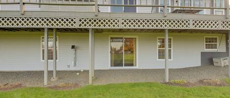 A two-story house with a covered porch, a garage, and a small lawn area.