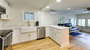 A modern kitchen with white cabinetry, a dishwasher, and a built-in oven. - Horseshoe Lake Vacation Rental w/ Deck & Kayaks! (Batavia)