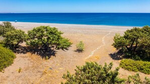 A coastal landscape with a clear view of the sea and a sandy beach.