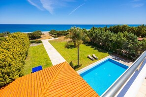 A rooftop pool with a clear view of the ocean, a pathway leading to the beach, and lush greenery surrounding the area. - Villa Pelagos Blue - Four Bedroom Villa, Sleeps 8 (Rhodes)