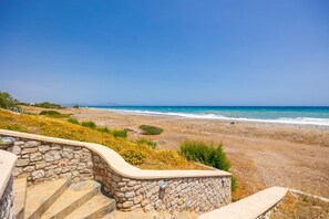 Una escalera de piedra que lleva a una playa con vista despejada al océano.