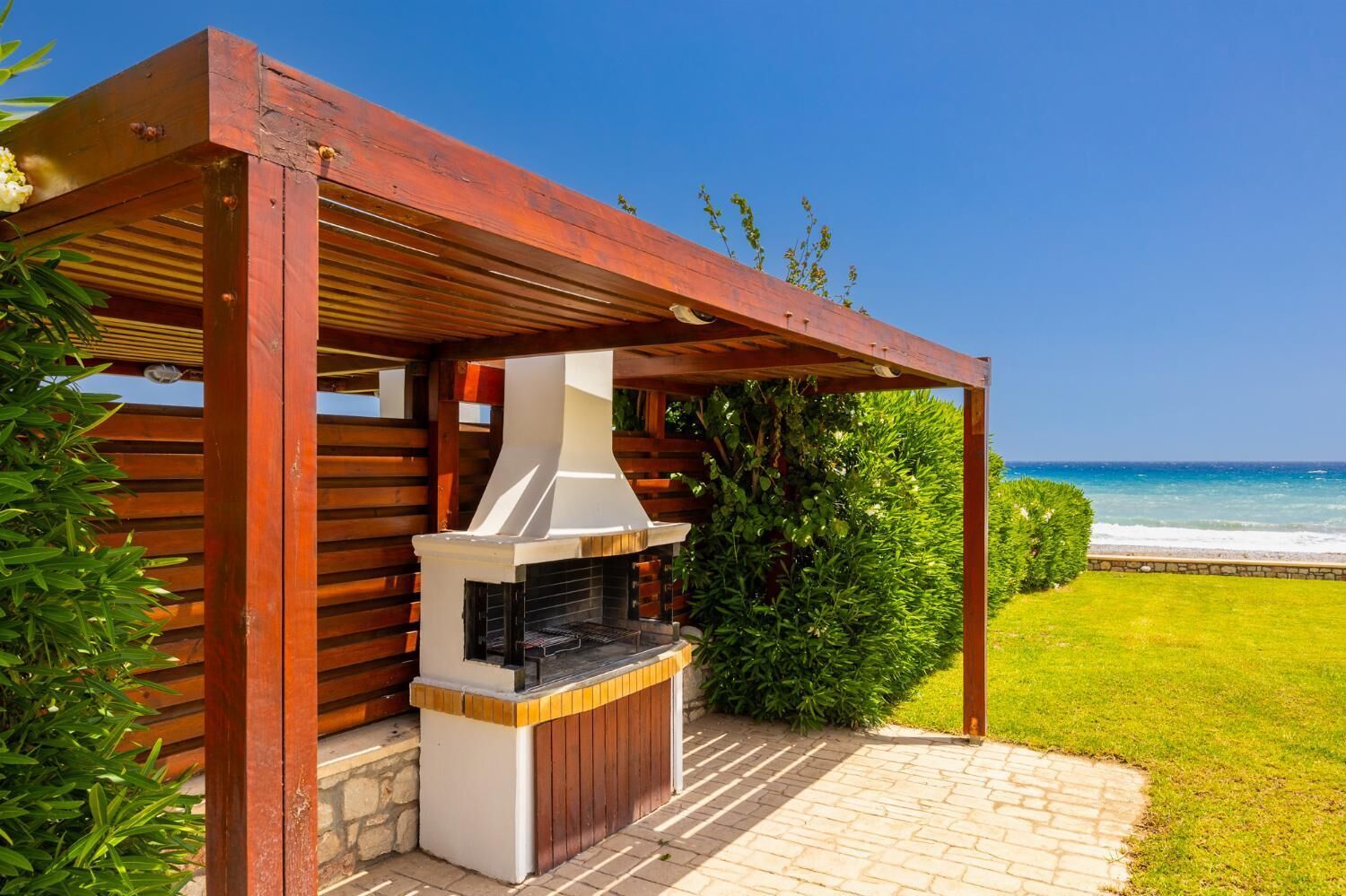 An outdoor barbecue area with a view of the ocean.