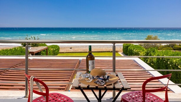 Eine Terrasse mit Tisch für zwei Personen, mit Blick auf Strand und Meer.