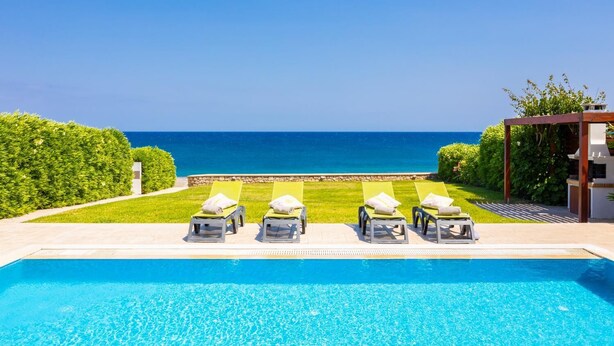 Una piscina amb gandules davant del mar.