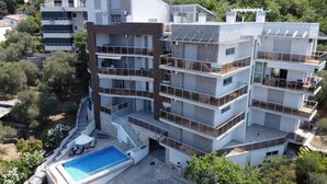 Ein mehrstöckiges Wohngebäude mit Pool auf dem Dach und einer Treppe zu den oberen Stockwerken.