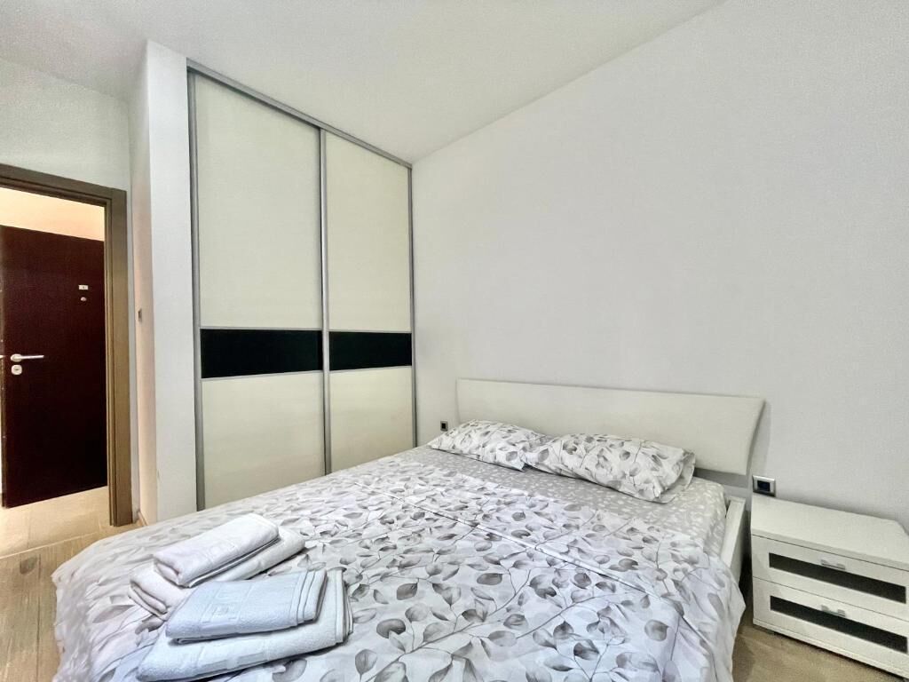 A bedroom with a bed, a wardrobe, and a radiator.