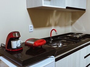 Een minikoelkast, kookgerei, borden en bestek