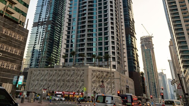 A tall, modern skyscraper with a glass facade, surrounded by other high-rise buildings.