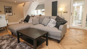 Una sala moderna con un sofá modular, una mesa de centro y una alfombra mullida.
