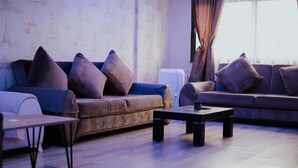 A modern living room with two sofas, a coffee table, and a small table. - De La Elpida Otel (Izmir)