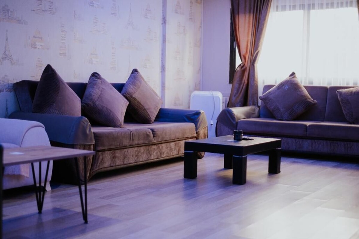 A modern living room with two sofas, a coffee table, and a small table.