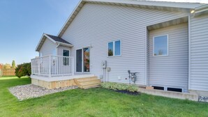 Ein zweistöckiges Haus mit überdachter Veranda und kleiner Terrasse.