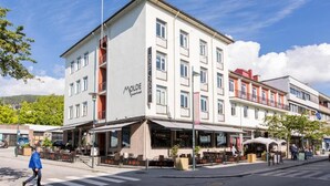 Hotel amb façana moderna, zona d'aigües obertes i pas de vianants.