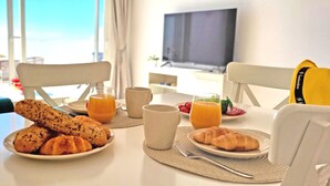 Ein Frühstückstisch mit Croissants, Orangensaft und einer Fruchtplatte.