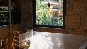 Una cucina con un'isola grande, mobili in legno e una finestra vista verde.