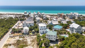 Un quartier résidentiel situé sur la côte, avec des maisons, une plage et une vue dégagée sur l’océan.