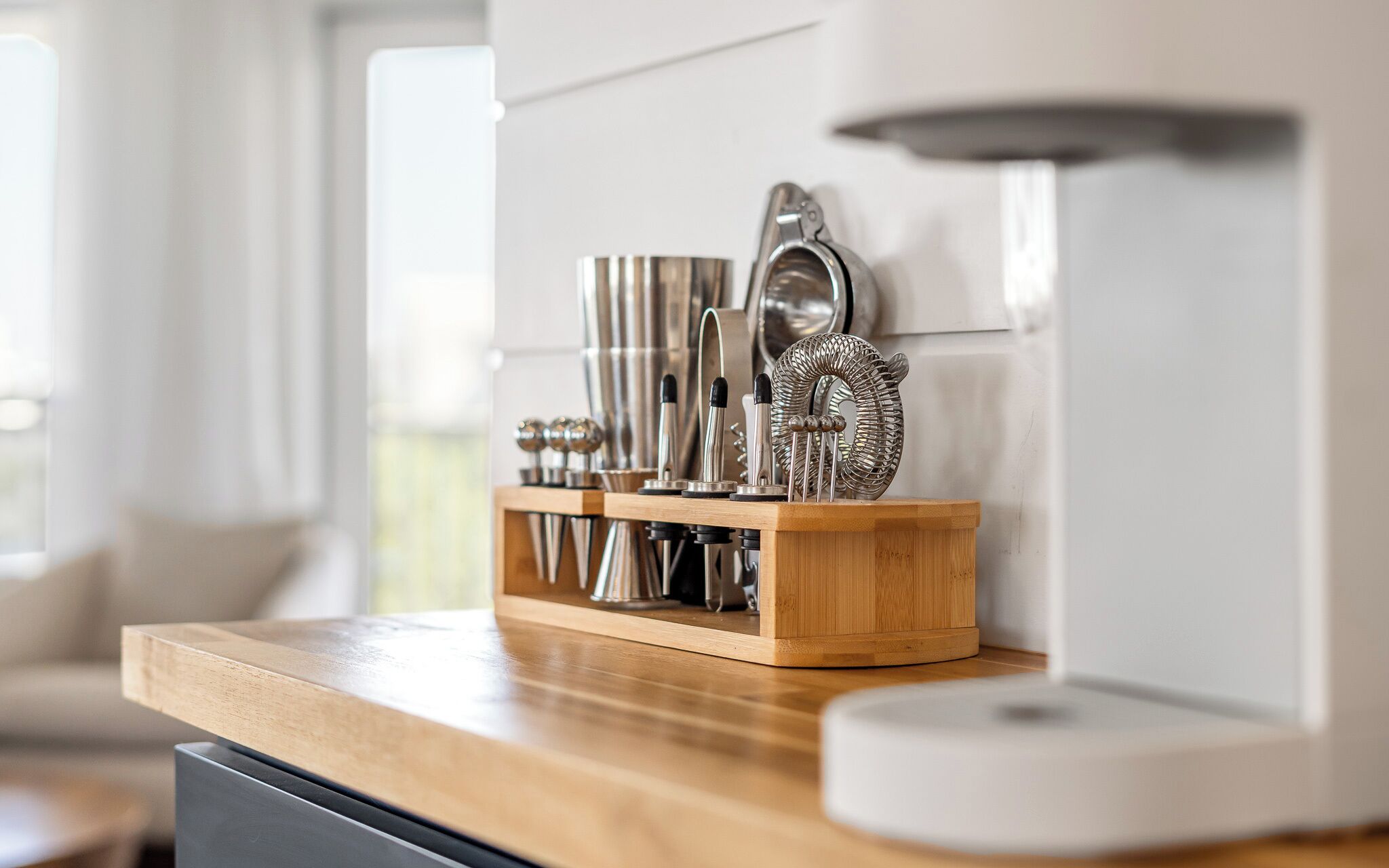 A kitchen counter with a wooden block holding various kitchen utensils and appliances.