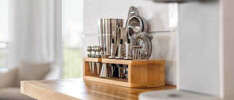 A kitchen counter with a wooden block holding various kitchen utensils and appliances.