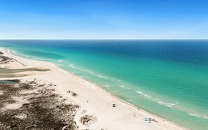 A beach with clear turquoise waters, sandy shore, and sparse vegetation. - Charming Cottage, 5 minute walk to State Park Beach, Pool, 3 bikes (Inlet Beach)
